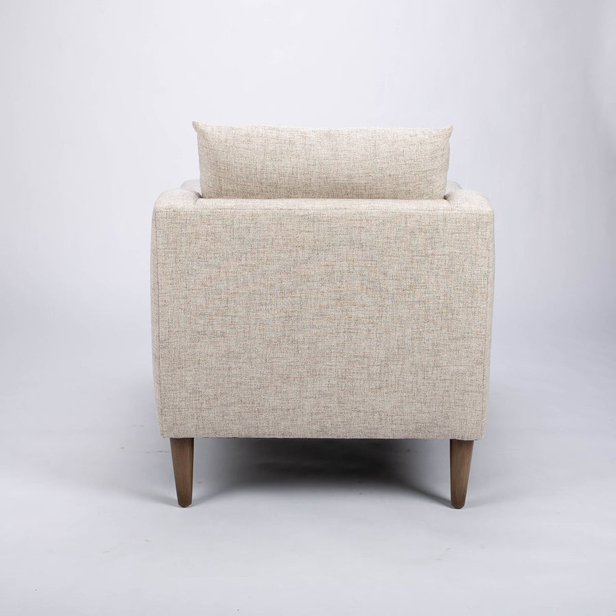 A white fabric Tea lounge stocked chair, back view.