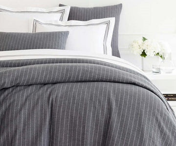 King size Chalk stripe Matelassé Duvet Cover in grey color, placed on a bed.