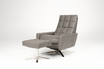 A grey leather Huron recliner and lounge chair with natural walnut four-star base and ottoman.