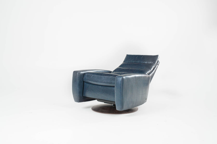 A blue Lanier leather recliner chair with the shape of classic automotive designs, reclined.