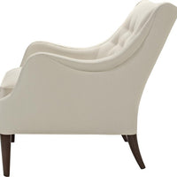A white Ludlow lounge chair with softly diamond-tufted back resting on elegantly on tapered posts and Dark Walnut finish. Side view.
