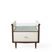 Hepburn Bedside - single drawered Vellum clad bedside table with Rosewood legs and Aged Brass detail. Has a top with scrolled sides, which supports a toughened glass top that rests above an Verre Eglomise insert.