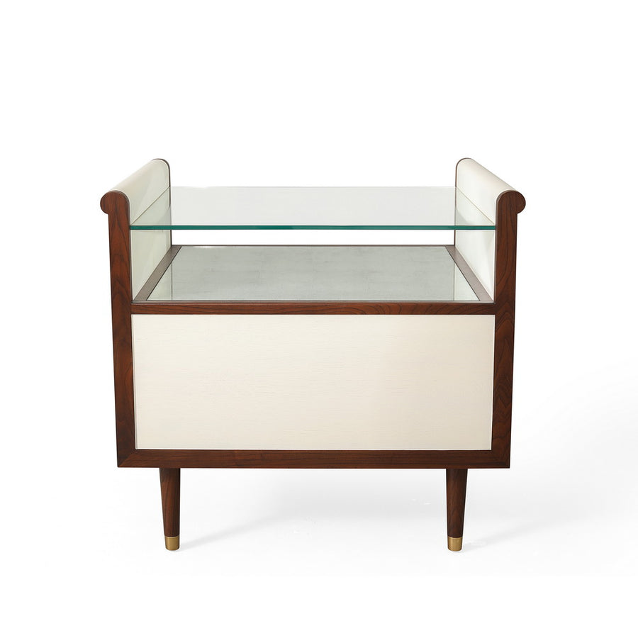 Hepburn Bedside - single drawered Vellum clad bedside table with Rosewood legs and Aged Brass detail. Has a top with scrolled sides, which supports a toughened glass top that rests above an Verre Eglomise insert, back view.