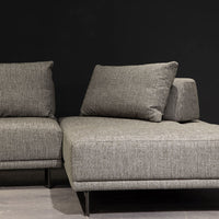 Grey fabric Felix Sectional with moveable back and arm rests and metal legs. Partial view of the right side.