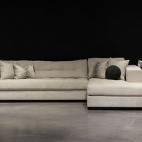 Large white Koda island sectional with soft, malleable arm, crafted and tailored with a solid wood plinth base,  long tufted bench seat and back cushions, plus lots of accent pillows.
