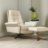 A white leather recliner chair with buttonless tufted back and seat and four star base and ottoman.