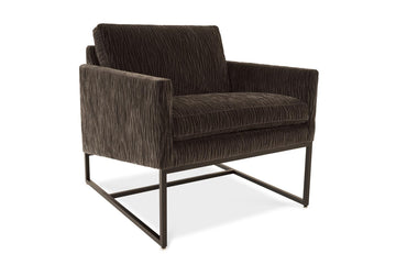 A brown Rebel lounge chair with angled side profile and metal frame.