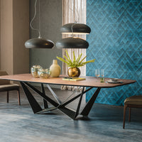 Wide Skorpio Dining Table with wooden top and origami based black base. Placed in a modern room with two matching dining chairs. 