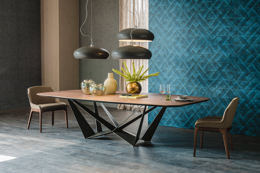 Wide Skorpio Dining Table with wooden top and origami based black base. Placed in a modern room with two matching dining chairs. 