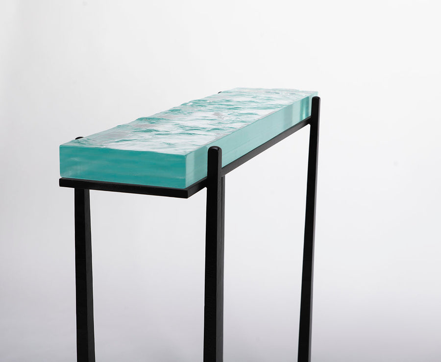 Cooper Console with subtle tapered legs and green facet glass top, closed up side view.