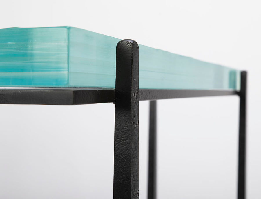 Cooper Console with subtle tapered legs and green facet glass top, closed up side view.