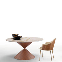 Fixed round Clessidra Dining Table with solid wooden steel base and wooden top, with two black bowls on it and a matching chair on it's right side.