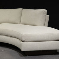 White curved Clip Sectional with the wood legs. Closed up side view.