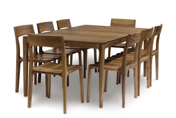 Lisse Extension dining table crafted in solid American black walnut hardwood with natural finish and with a single self-storing butterfly leaf for single handed operation. Shown with eight matching chairs around it.