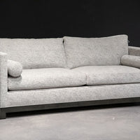 Grey two seat Oscar Sofa that features a slim tuxedo style, foam and down seats, arm bolsters and parson legs. Front and side  view.