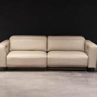 White leather two seat Turin sofa with splayed metal legs and power mechanism that operates the headrest and footrest independently