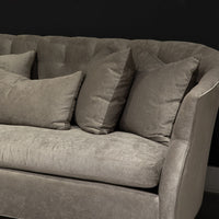 Light grey Luccia Sofa with subtle pin tufting on the inside back, comfortable bench seat, double-stitch back and high, curved arms. Closed up view.