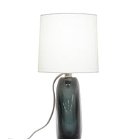 Nellie Table Lamp with a bold oval base, sophisticated polished nickel finish and off-white linen shade.