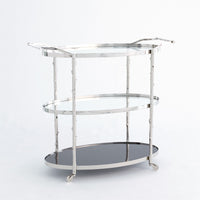 Arbor 3 level Bar Cart with twig textured detailing on the supports and handles, a solid white marble bottom shelf, and two glass upper shelves with solid brass pivoting wheels.