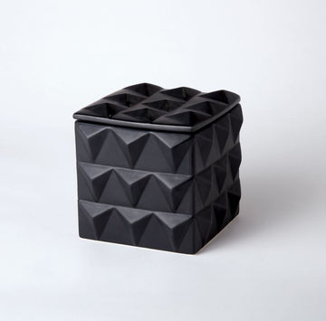 Braque box with matte black finish and sculpted facets with striking angularity.