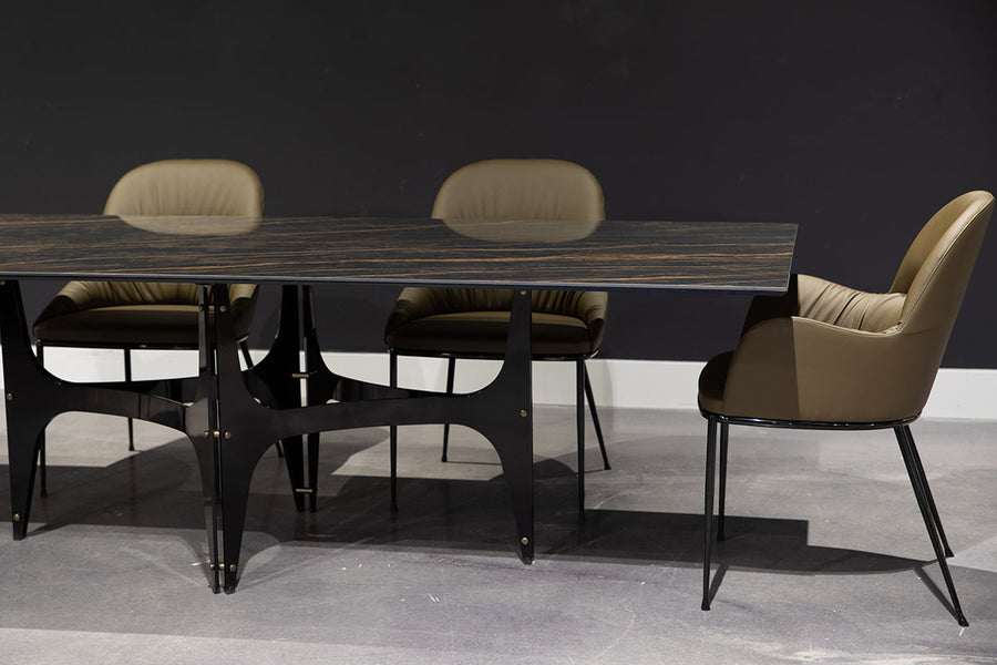 Fixed rectangular Universe Dining Table with lacquered metal frame and decorative details and with anti-scratch SuperMarble top. Placed in a room with three leather dining chairs.