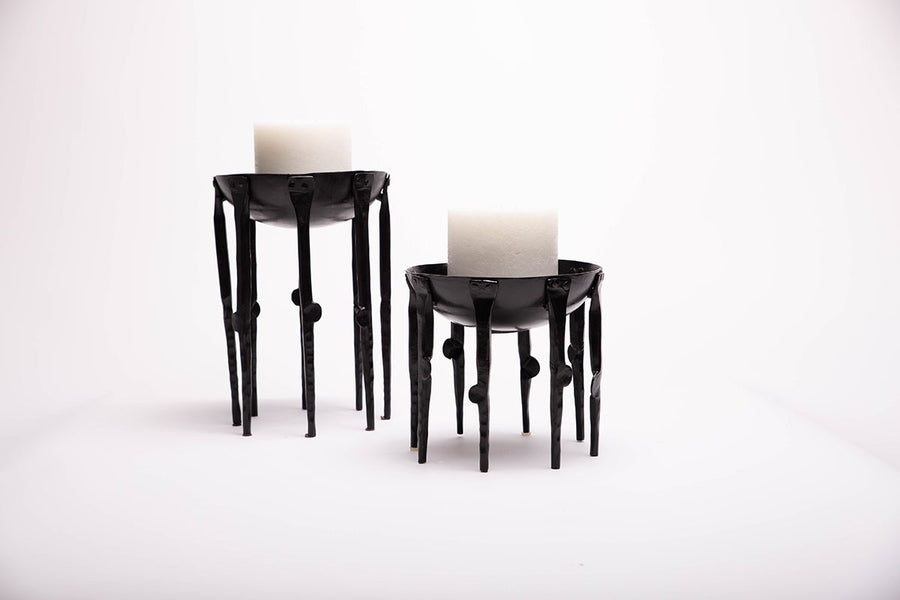 Two black Medieval-inspired iron candleholders.