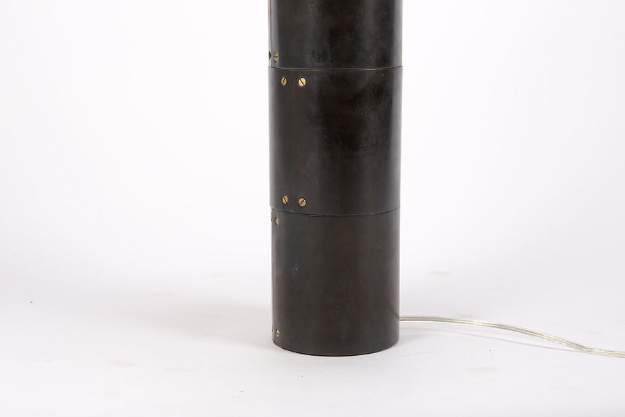 Yul table lamp with cylindrical brass plates applied to create a simple clean, industrial form. Closed up view on the body.