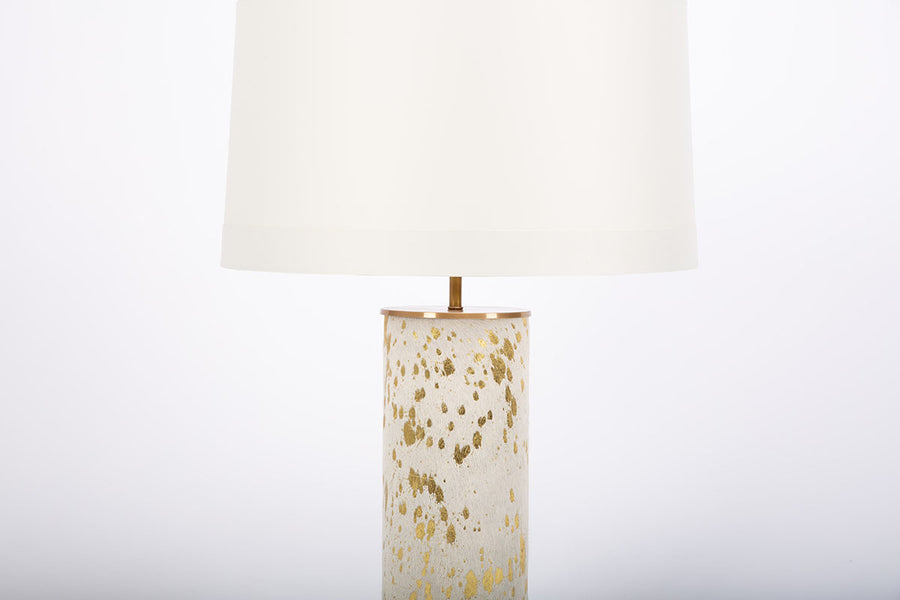 Hand crafted Sheena lamp with acid etched pattern and gold leaf finish on hide and with white drum shade.