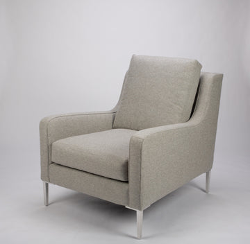 A light grey mid size lounge chair with classic shape and white legs. Front and side view.