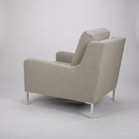A light grey mid size lounge chair with classic shape and white legs. Side and back view.