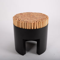 Black Chiquita stool with rigid-looking vertical sections of rattan poles that recede into the seat.