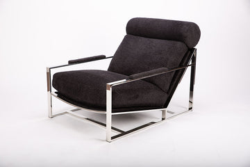 Dark grey Cruisin lounge chair with  a brushed bronze frame, cylindrical headrest and padded arms combined with the luxurious seat and back. 