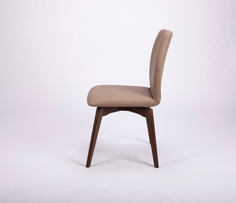 A beige Hexa swivel dining chair with wood base. Side view.