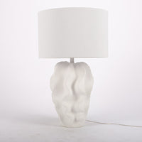 White Bethany Table Lamp with undulating curves of textured resin cascading into an urn shape.
