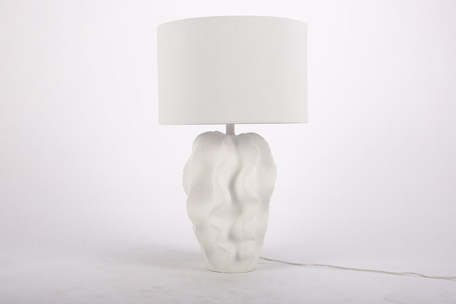 White Bethany Table Lamp with undulating curves of textured resin cascading into an urn shape.