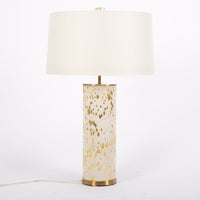Hand crafted Sheena lamp with acid etched pattern and gold leaf finish on hide and with white drum shade.
