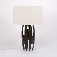 Naomi Lamp with an off-white linen drum shade and the black body done in the Brutalist style characterized by abstracted organic forms with rough textures.