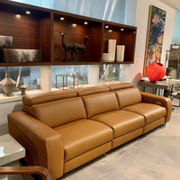 Orange leather Vogue three seater sofa equipped with a state of the art power mechanism and touchpad that individually controls headrest and footrest.
