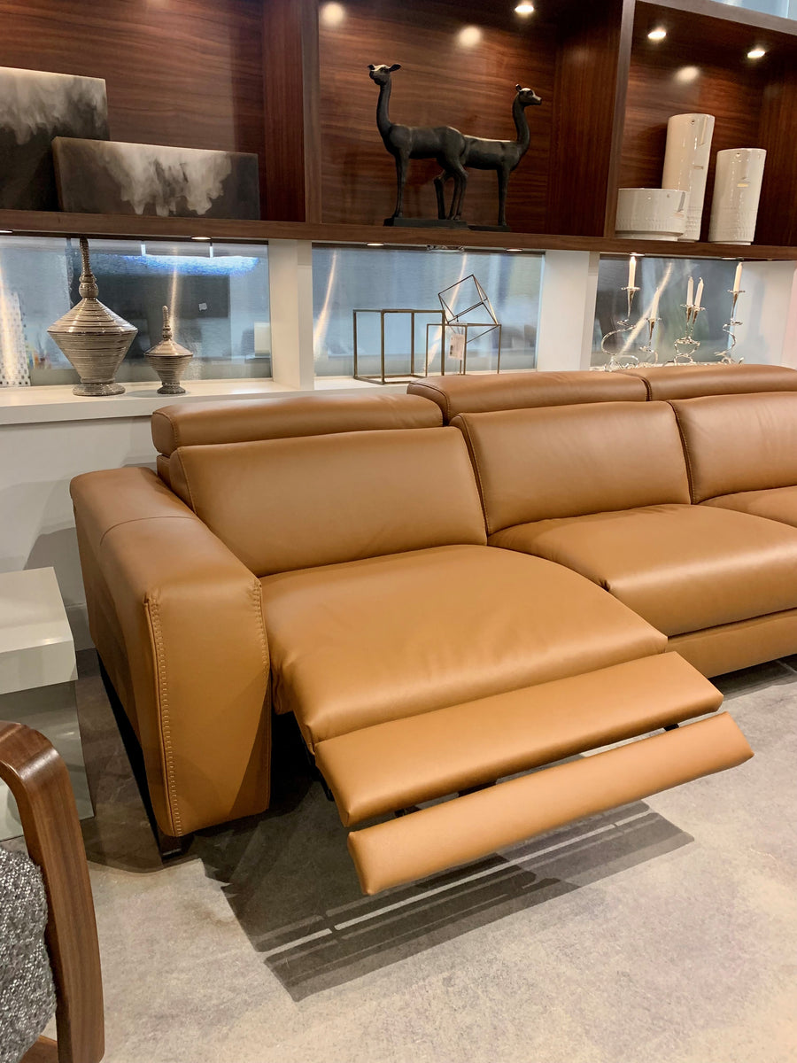Orange leather Vogue three seater sofa equipped with a state of the art power mechanism and touchpad that individually controls headrest and footrest. Left side reclined.