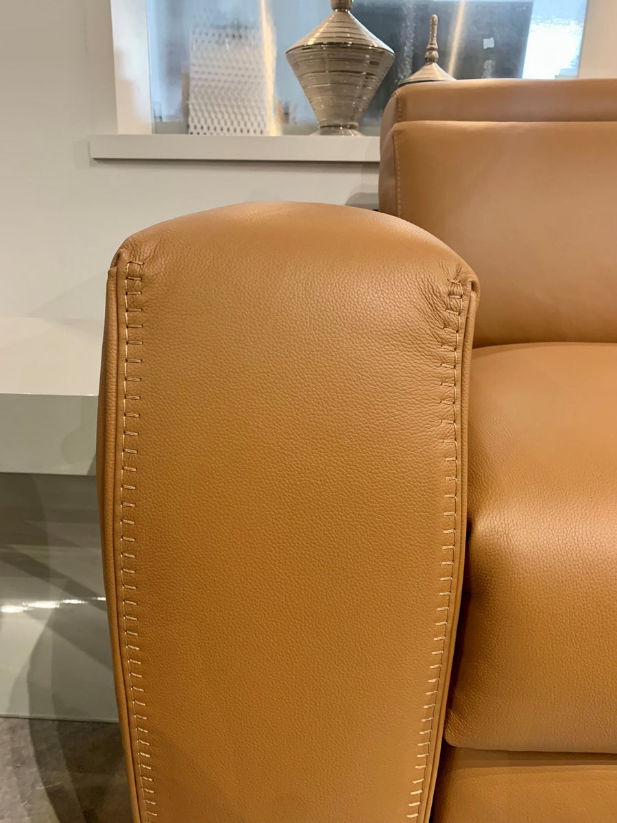 Orange leather Vogue three seater sofa equipped with a state of the art power mechanism and touchpad that individually controls headrest and footrest. Closed up arm rest view.